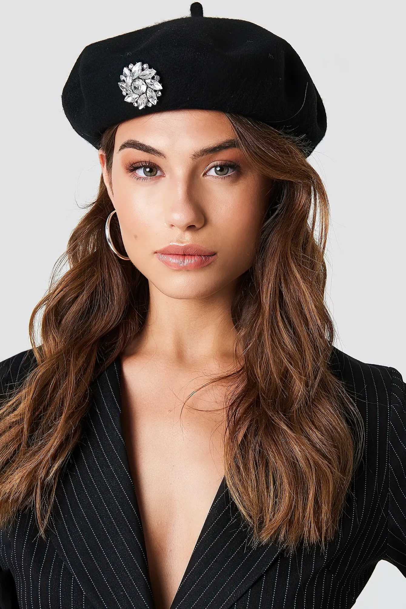 Close up image of brunette woman wearing a black beret