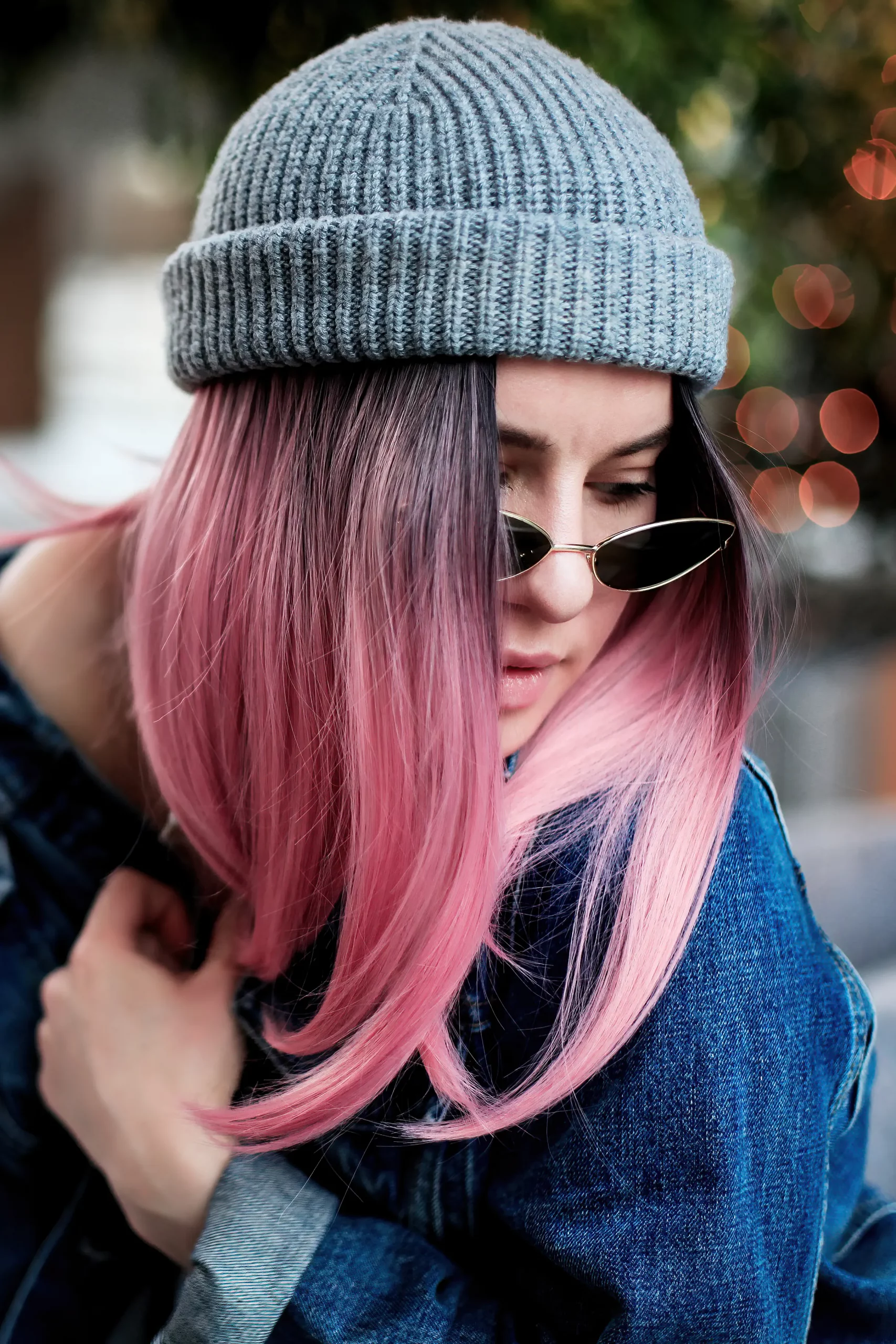 Woman with pink hair wearing denim jacket blue beanie