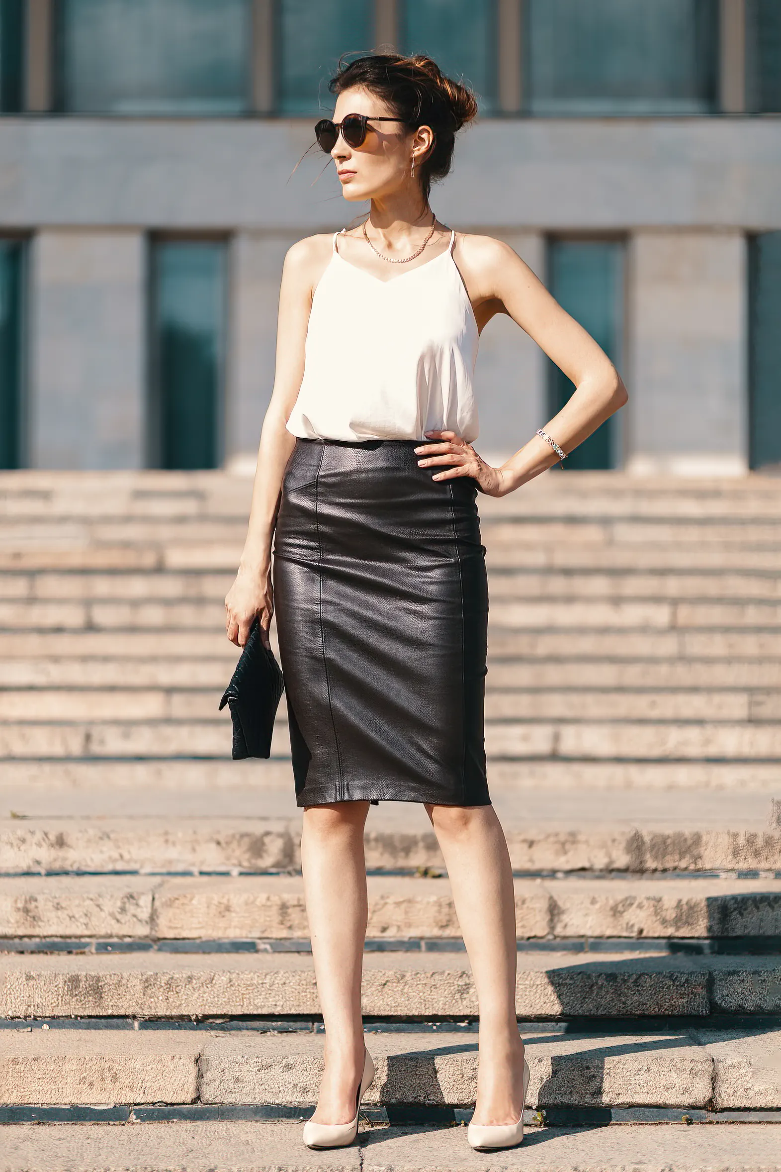 Fashionable brunette businesswoman at stair wearing black leather pencil skirt