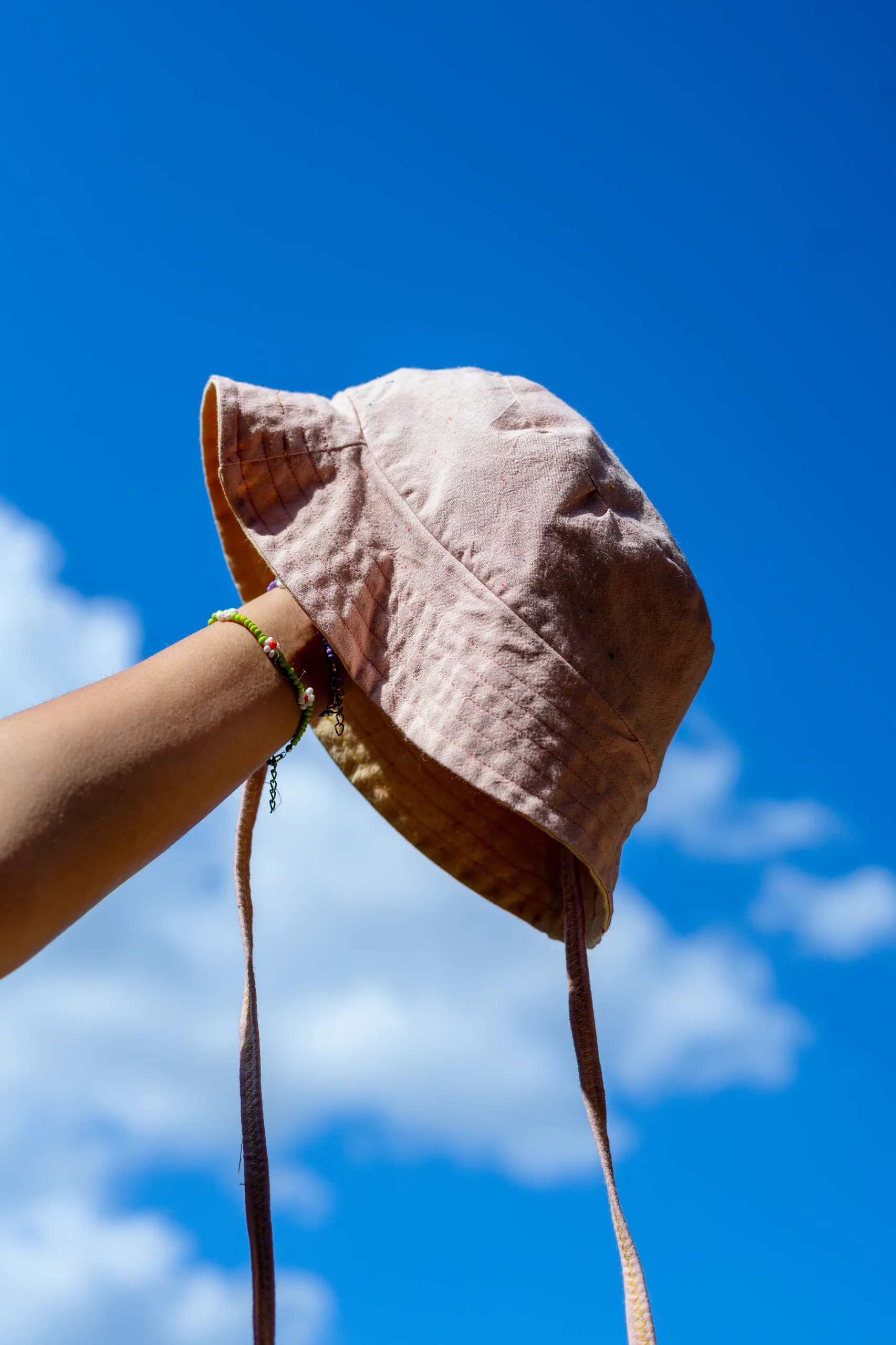 Close-up of a hand holding a pink bucket hat