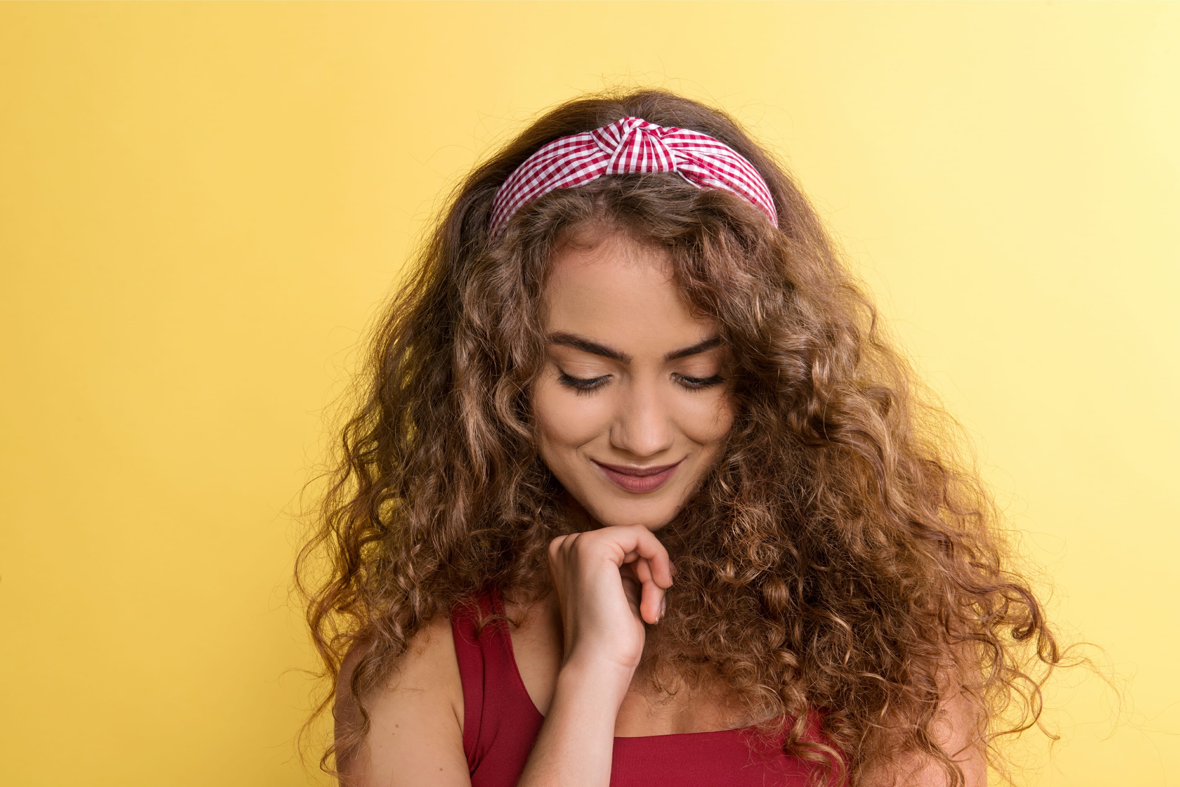 Young woman wearing headband with yellow background