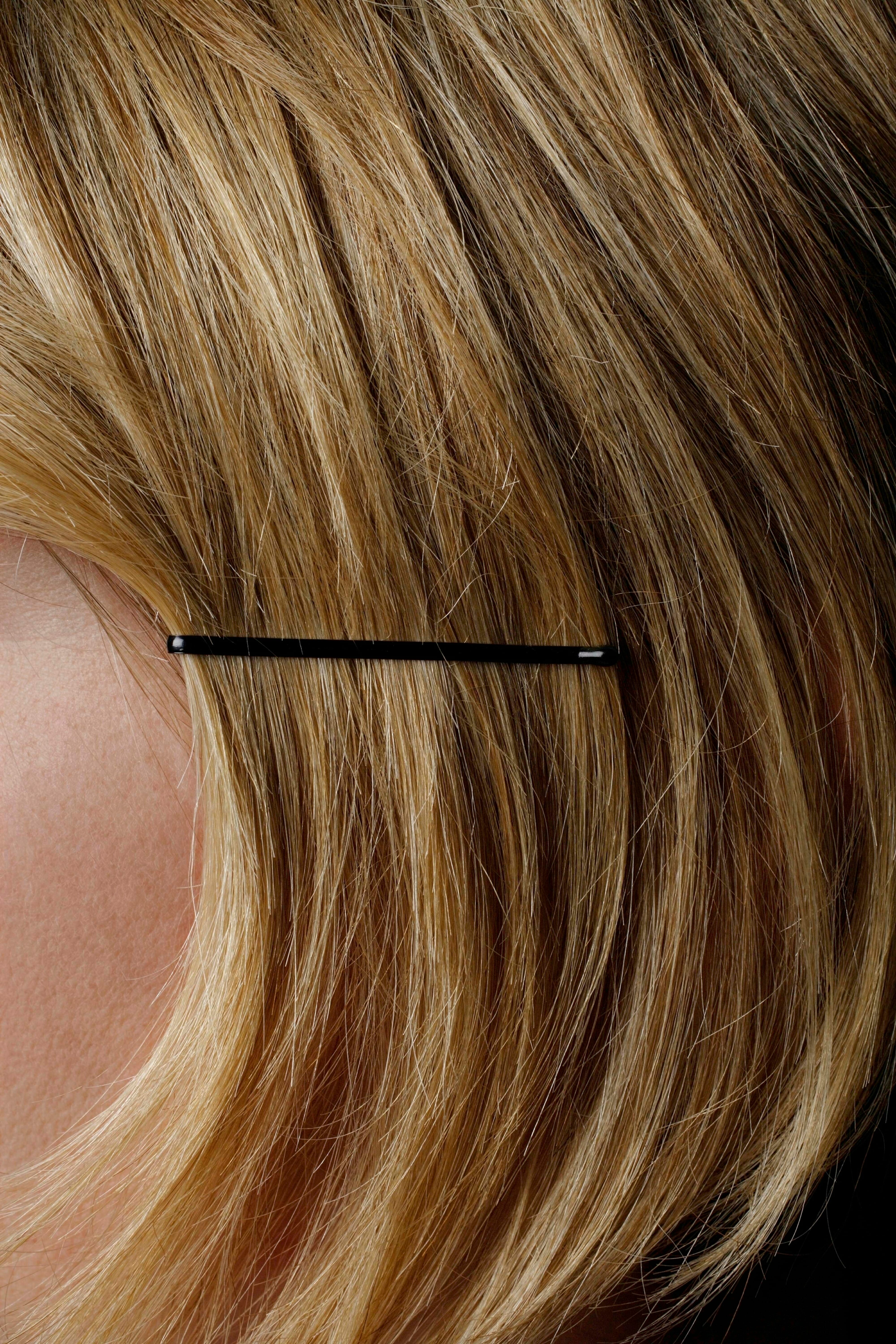 The bobby pin holding back woman hair